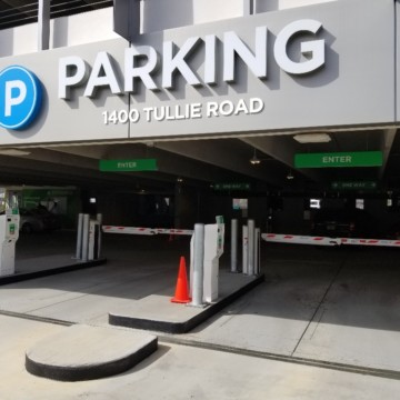 Entrance to secure parking garage with ticket system at entrance for vehicles.