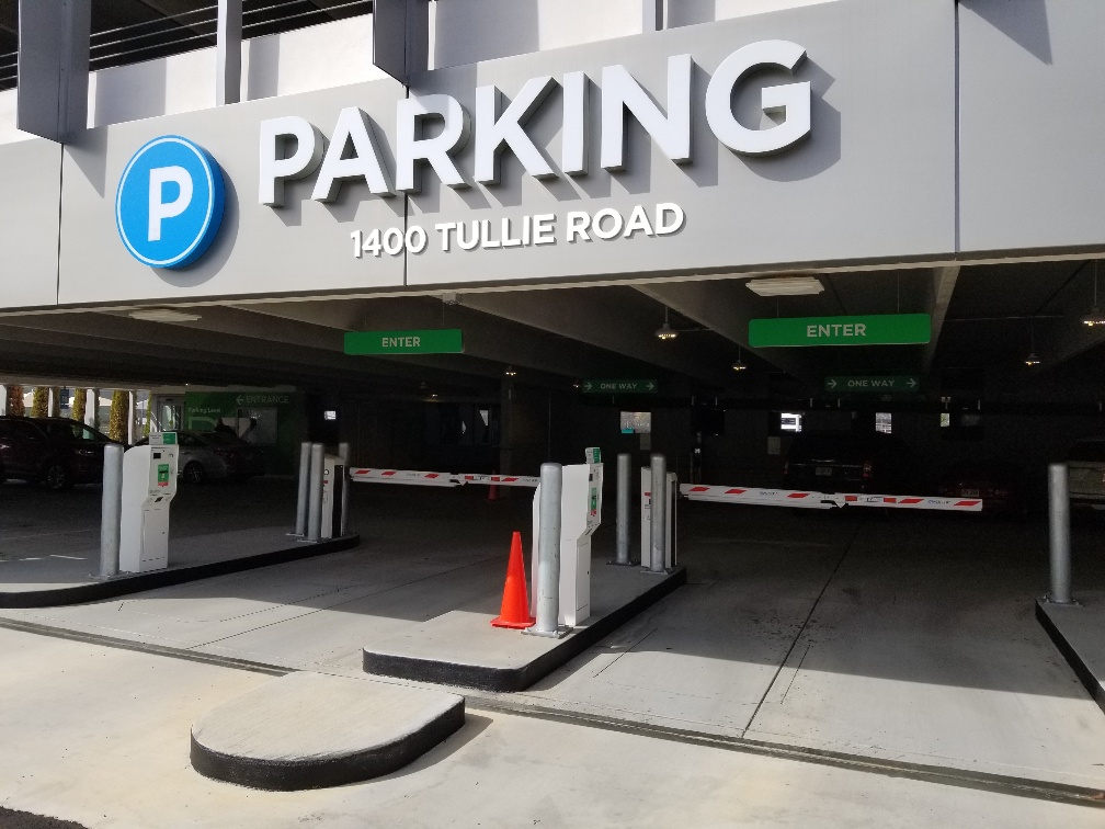 Entrance to secure parking garage with ticket system at entrance for vehicles.