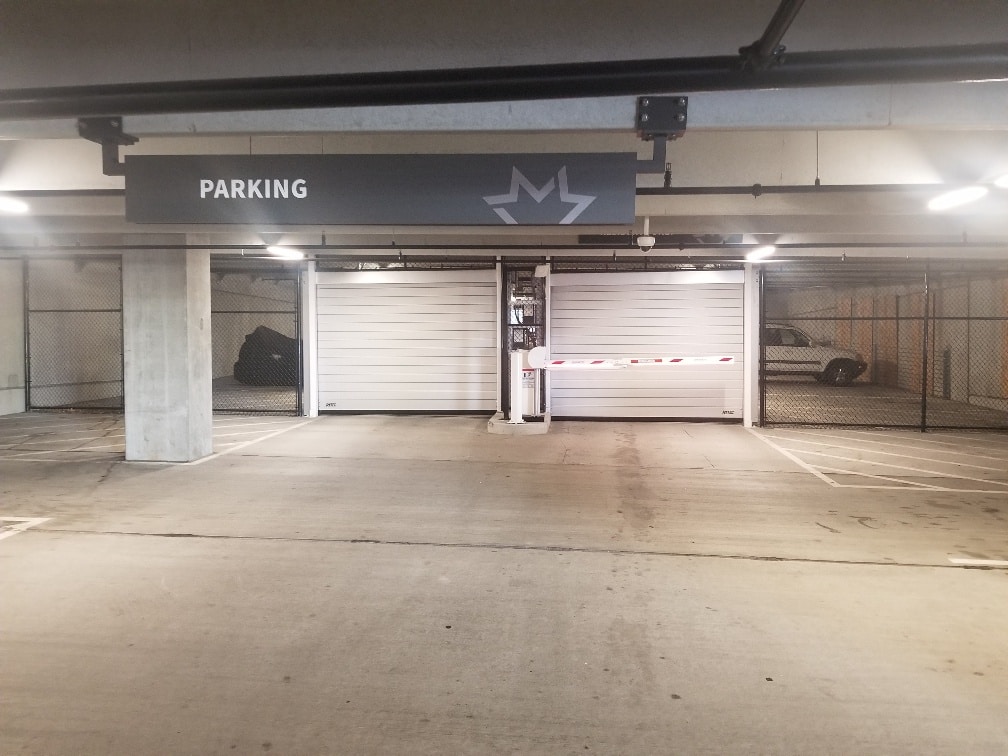 Entrance and exit overhead doors closed with security fence enclosing parking area.