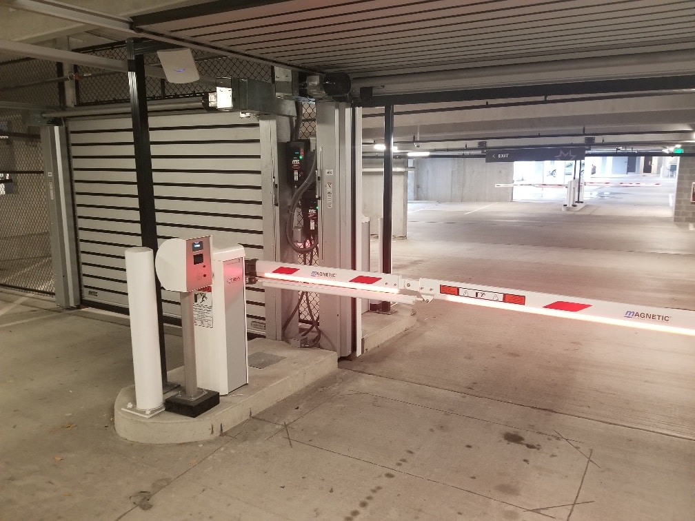 Scanner entry system to secure parking area with overhead door and security lift gate arm.