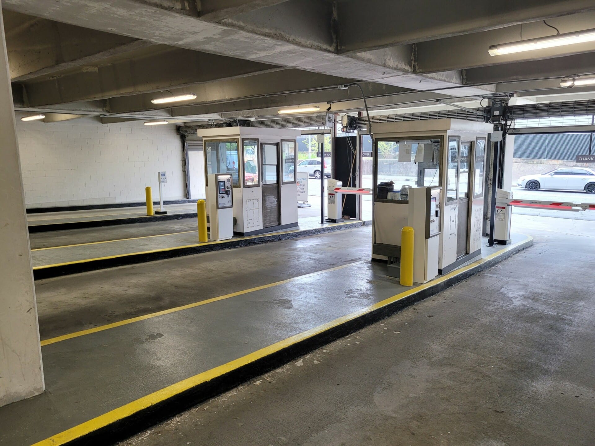Security guard booths sit on two lanes shown for secure parking access and exiting.