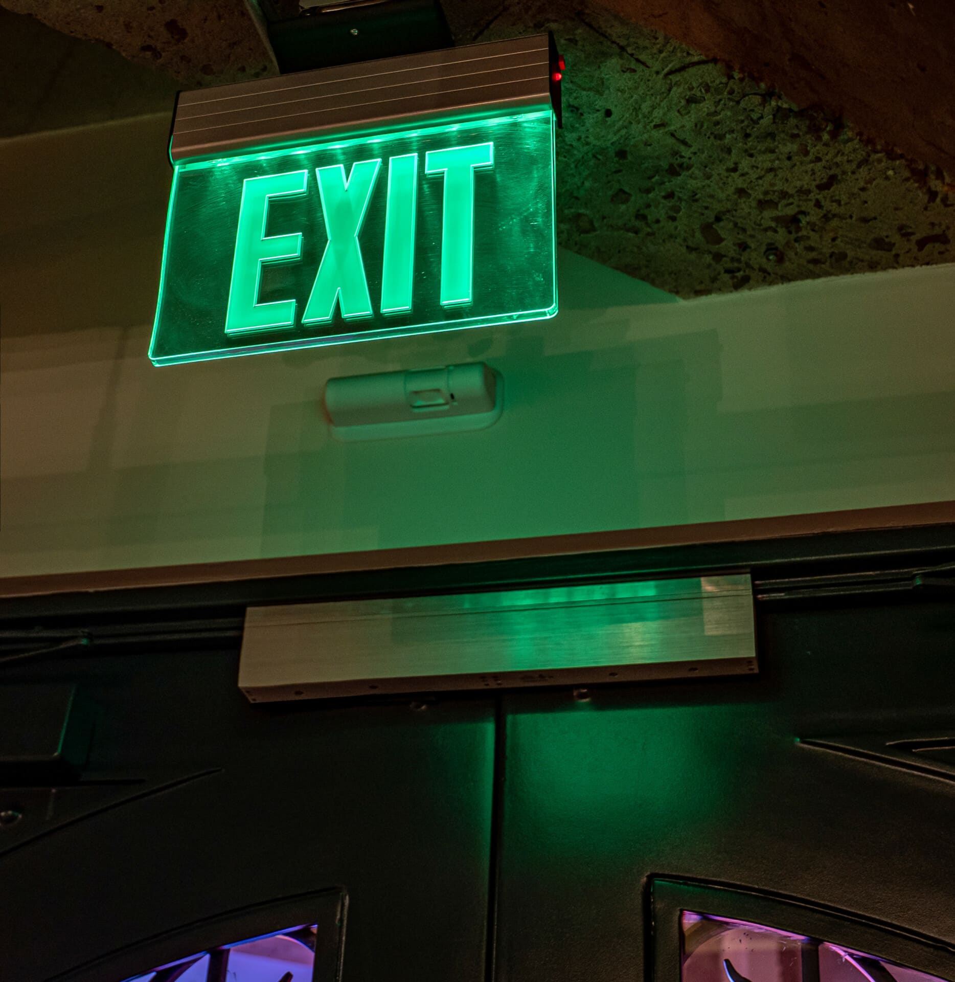 Interior exit sign with green lighting.