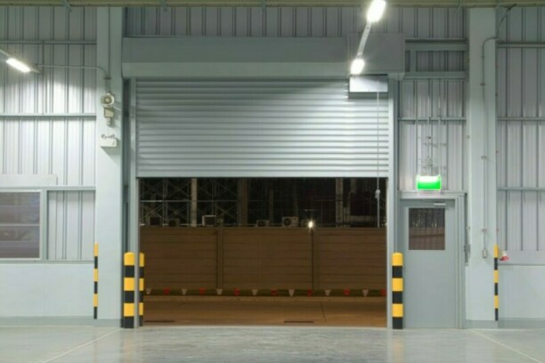 Overhead door of a business closing at night.