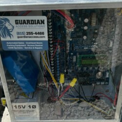Guardian Access Control electric gate system box with number for service and maintenance.