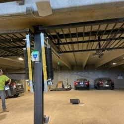 Parking garage with cars in the background in an automatic gate closure area, with gate in the upright position.