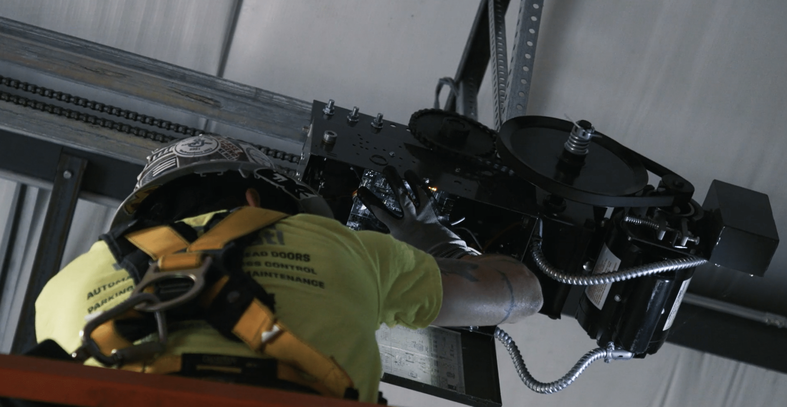 Guardian service technician performs routine maintenance on overhead door mechanical system.