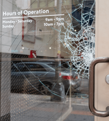 Broken glass on commercial entry door from vandalism and property crime