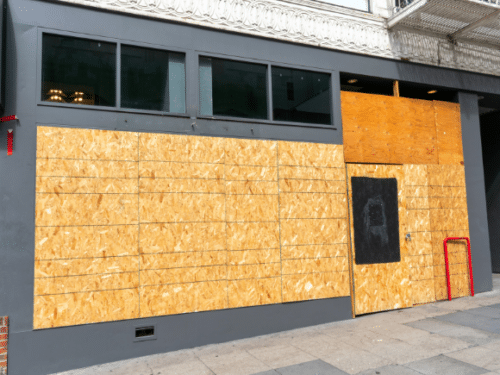 business windows boarded up for incoming storm